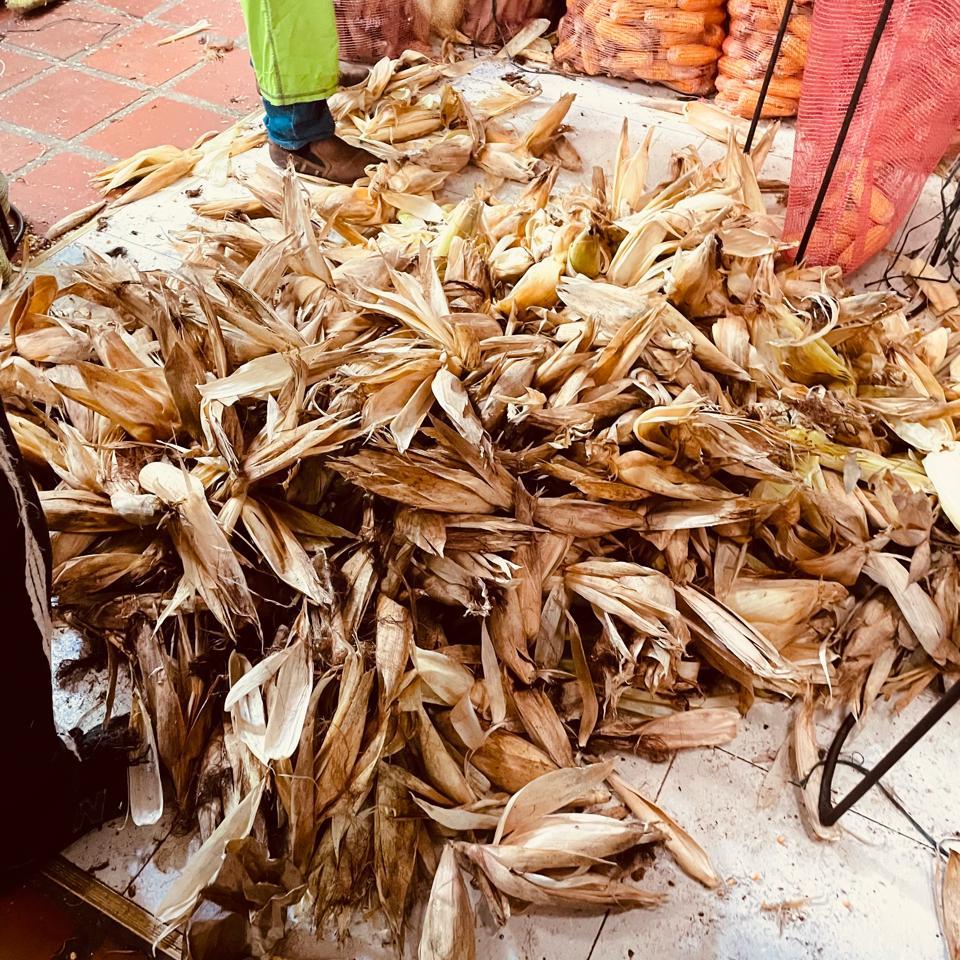 Hojas secas de mazorca apiladas en un puesto del mercado de Medellín