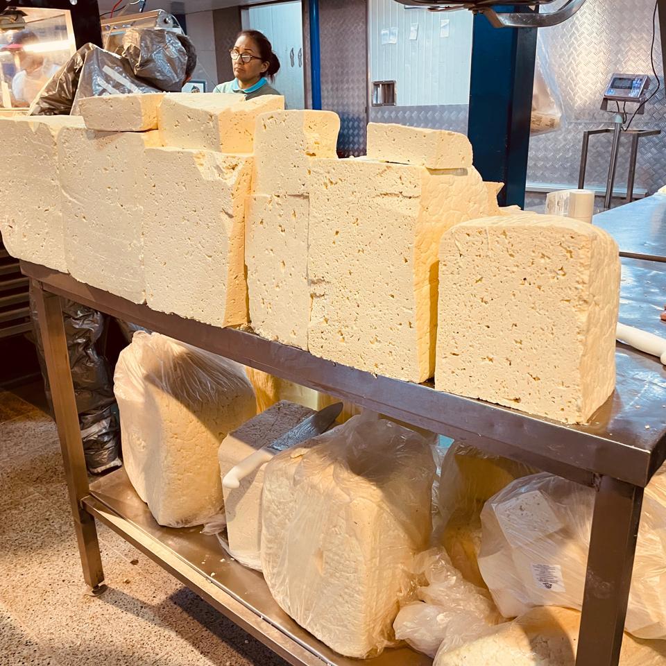 Bloques de queso costeño exhibidos en un puesto del mercado de Medellín